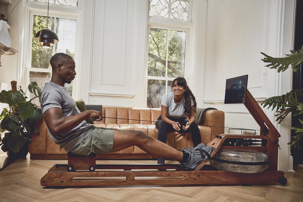 Couple working out on the Ergatta rower in their living room